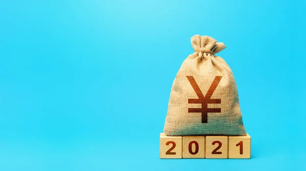 stock image Yuan Yen money bag and blocks 2021. Budget planning for next year. Revenues expenses, investment and financing. Beginning of new decade. Business plans and development prospects, trends and challenges