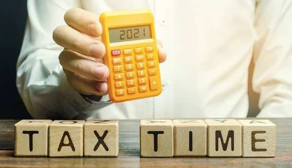 木块上写着纳税时间 纳税人上写着2021年计算器 支付税率的概念 税务负担 还了债财产收入年度税 — 图库照片