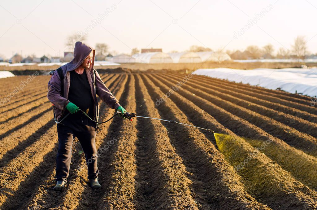 The farmer treats the field from weeds and grass for growing potatoes. Use chemicals in agriculture. Harvest processing. Agriculture and agribusiness. Protection and care. Growing vegetables
