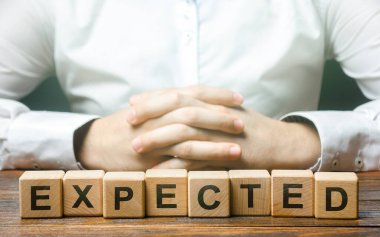 Folded hands on a background of word Expected. Foresight and foresight concept. Be prepared for any possible situation. Planning and solution development. Confidence. Expectability. Case scenario