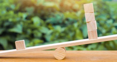 Terazideki bir tahta blok diğer dördünden ağır basıyor. Eşitsizlik kavramı. Biri diğerlerine karşı. Liderlik ve benzersizlik. Eşsiz, karşıt görüşlü, bireysel ve kalabalıktan uzak.