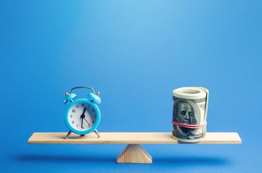 Mavi çalar saat ve terazide bir tomar dolar. Saatlik adil ücret. Zaman takibi. Depozito, para yatırımı. Kârlılık ve yatırımdan kazanç. Kiralık. Hayat ve kariyer arasındaki denge.