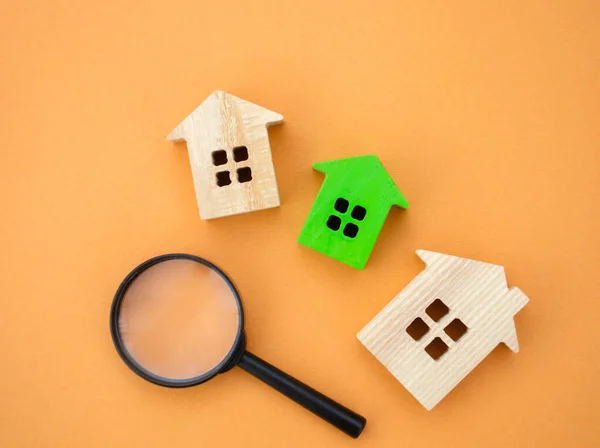 Magnifying glass and wooden houses. House searching concept. Home appraisal. Property valuation. Choice of location for the construction. Search for housing, apartments. Real estate appraiser services