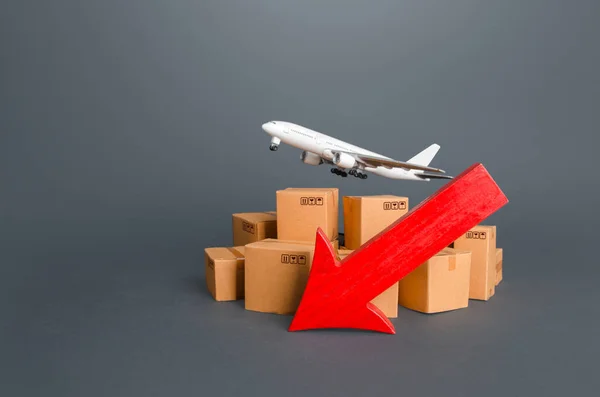 Airplane over boxes and red down arrow. Decline of goods transportation volume, world trade traffic delays. Delivery by air. High demand and low proposition for express delivery. Cargo aircraft