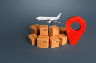Kutuların üzerinde kargo uçağı ve kırmızı iğne konum sembolü. Ekspres teslimat ve uçakla mal taşıma hizmetleri. Dünya Ticaret ve Lojistik. İş ve ticaret, ürünlerin ithalatı.