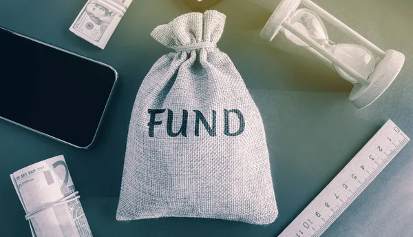 A bag with money and the word Fund. The concept of providing financial resources to organizations and enterprises. Credit, donations, taxes, grants, savings and subsidies. Business, finance. Funding