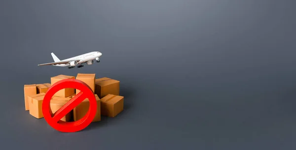 Cargo plane, boxes and red prohibition symbol NO. Embargo and sanctions. A ban on flights. Non-flying zone. Lack of air transport capacity. Freight and shipping. Delivery. Loss of parcels.