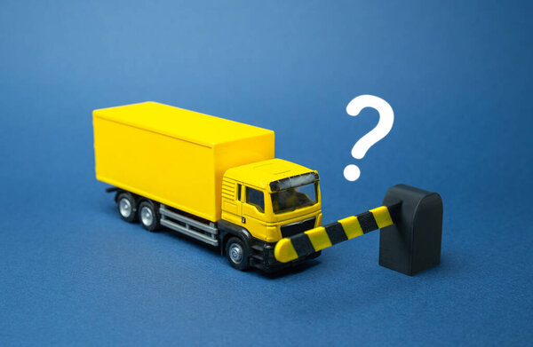The closed barrier does not let the truck through. Stoppage of transportation, border closures and embargo. Logistics disruption, customs issues, and trade restrictions. Global trade problems