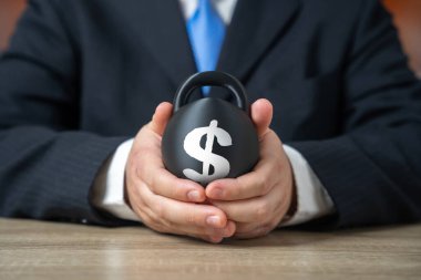 Bir iş adamının elinde ağır bir borç yükü. Artan faiz maliyetleri risk yaratır. Yükümlülüklerin ağırlığı gelişimi yavaşlatır. Bir iş adamının elinde ağır bir borç yükü var..