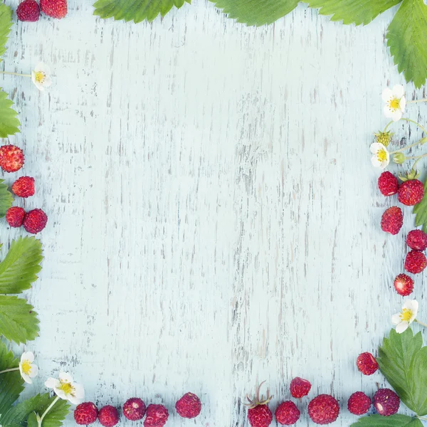 Walderdbeeren auf hellblauem Holzhintergrund — Stockfoto