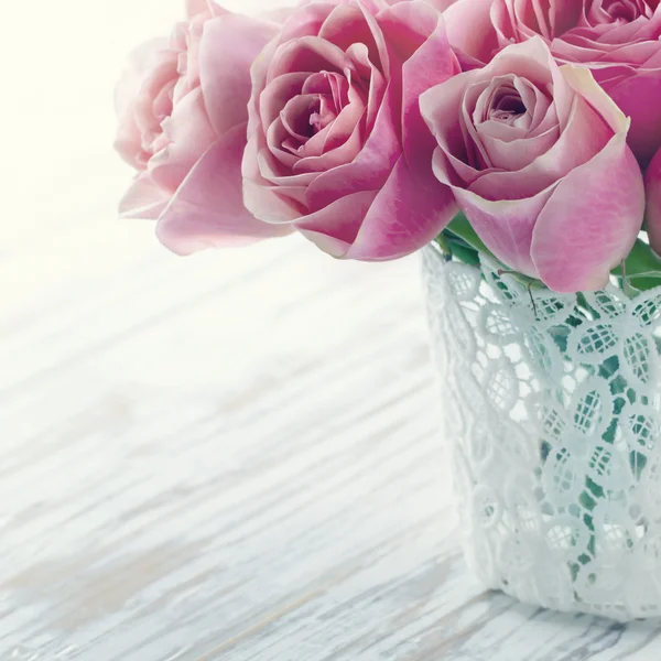Ροζ τριαντάφυλλα σε ένα βάζο με λευκή δαντέλα — Φωτογραφία Αρχείου