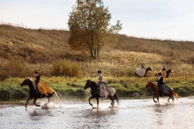 04.10.2020 Rusya, Moskova. Ata binen bir grup atlı kadın nehri dörtnala geçmeye zorluyor.