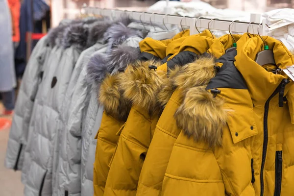Gama otoño-invierno de prendas de abrigo en la tienda. Abrigos amarillos y grises — Foto de Stock