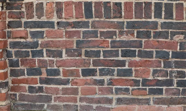 O fundo é uma parede vertical de tijolo. Pedra preta e vermelha — Fotografia de Stock