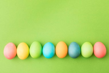 Yeşil arka planda renkli Paskalya yumurtaları.