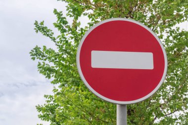 Yol tabelası, ahşap yeşilliklerin arka planına karşı yasaktır.