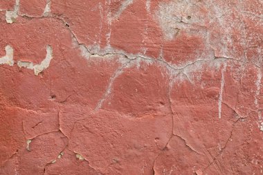 Duvarın arka planı kahverengidir. Yüzey boyanmış, beton kaplama yıpranmış.