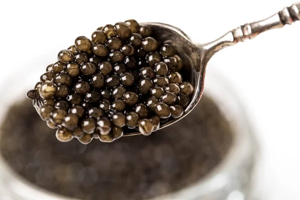 Une pleine cuillerée de caviar de béluga noir au premier plan avec acuité. Fond blanc — Photo