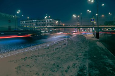 Karla kaplı şehrin gece manzarası. - Evet. Trafiğin ışıkları uzun pozlarda çekiliyor.