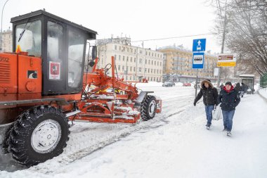 13.02.2021, Rusya, Moskova. Kar yağdıktan sonra traktörle bir kova karla yolu temizliyorum.
