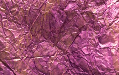 Arka plan metalik yüzey lekeli buruşuk renkli kağıtlardan oluşuyor. Mor ve altın.