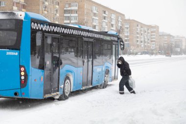 13.02.2021, Rusya, Moskova. Şehirde kar yağışı. Duraktaki toplu taşıma yolcuları kar yığınlarının üzerinden atlıyorlar.