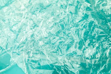 Saf su renginde renkli kağıt üzerinde basılmış plastik filmden. Küresel okyanus kirliliği kavramı, gezegen.