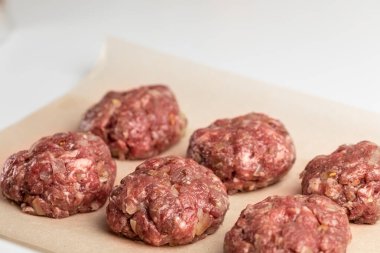 Parşömen kağıdında pişmemiş sığır pirzolası. Vejetaryen olmayan bir akşam yemeği pişirme süreci. Yazı için yer