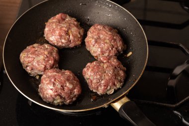 Kızartma tavasında biftek ve pirzola pişirme işlemi.