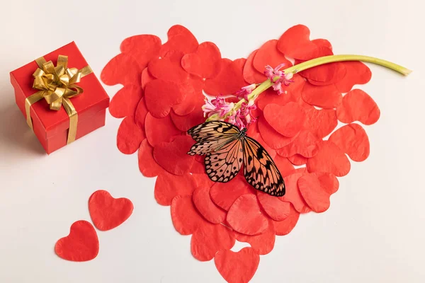 A symbol of love, health. The large sergeant on a white background consists of small paper hearts, a box with a gift