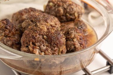 Cam bir kabın içinde ev yapımı sığır eti ve domuz pirzolası hazır. Kapağı aralık. beyaz arkaplan