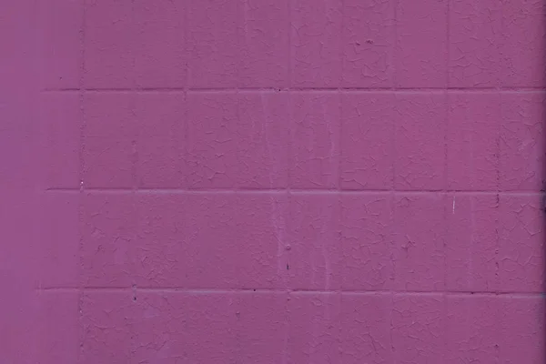 背景はタイル張りで、ピンクの油絵具で描かれています。塗料の表面が割れました。壁の壁画の色 — ストック写真