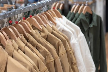 Mağazadaki askılarda asılı kıyafetlerin olduğu bir sergi. Erkekler ve kadınlar için günlük ceketler.