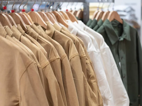 Mağazadaki askılarda asılı kıyafetlerin olduğu bir sergi. Erkekler ve kadınlar için günlük ceketler. — Stok fotoğraf