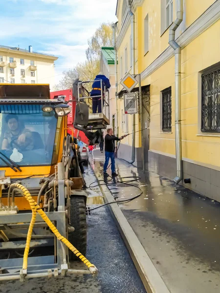 19.04.2021,ロシア,モスクワ.市のユーティリティは、高圧で建物のファサードを洗浄します。. — ストック写真