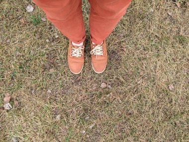 Bacaklar günlük rahat ayakkabılara sarılmış. Yukarıdan görüntüle