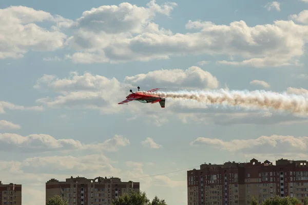 22 мая 2021 года, Россия, Москва. Красный легкомоторный маленький самолет летает вверх ногами вдоль аэродрома. — стоковое фото