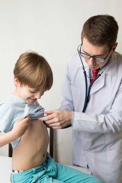 Ο παιδίατρος εξετάζει το παιδί με στηθοσκόπιο. Ελέγχει την καρδιά και τους πνεύμονες. — Φωτογραφία Αρχείου