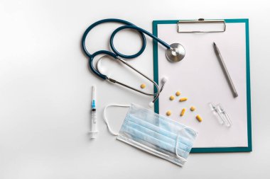 The concept of medical care. A stethoscope, a protective mask, tablets, a syringe with a vaccine. Doctors workplace