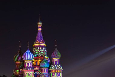 St. Basils Katedrali 'nin parlak renkli ışıklarıyla aydınlanan kubbeleri gece gökyüzünün arka planına karşıdır..