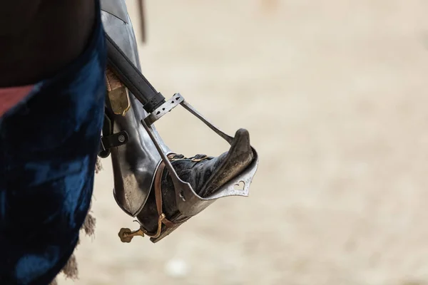 Close-up of the riders leg in historical armor on a horse. Shoes with a long nose in metal protection in stirrups. — Stock Photo, Image