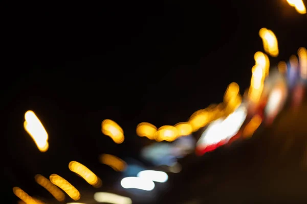 Night illumination lights over a wet road. Bokeh holiday lighting — Stock Photo, Image