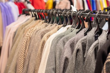 Sonbahar kış koleksiyonu kadın dış giyim mağazada askıda. Houndstooth Paltoları ve ceketleri
