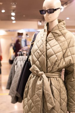 Kemerin altına bej renkli yorgan desenli manken. Modern bir kadının trend görünüşü