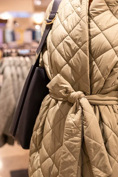Primer plano de los detalles de la apariencia otoñal de un abrigo acolchado para mujer. maniquí en la tienda — Foto de Stock