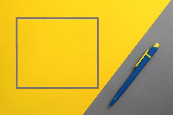 Modré Pero Leží Šedém Žlutém Pozadí Blízkosti Rámec Pro Text — Stock fotografie