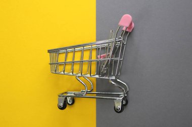 Alışveriş arabası aynı anda sarı ve gri üzerinde yatıyor.