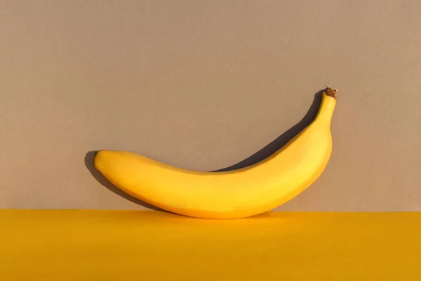 yellow ripe banana on yellow and gray backgrounds