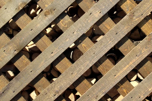 木料堆在木制栅栏后面的谷仓里 — 图库照片