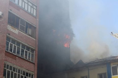 Sıcak, güneşli bir günde, yazın yanan bir binanın bulanık fotoğrafı.